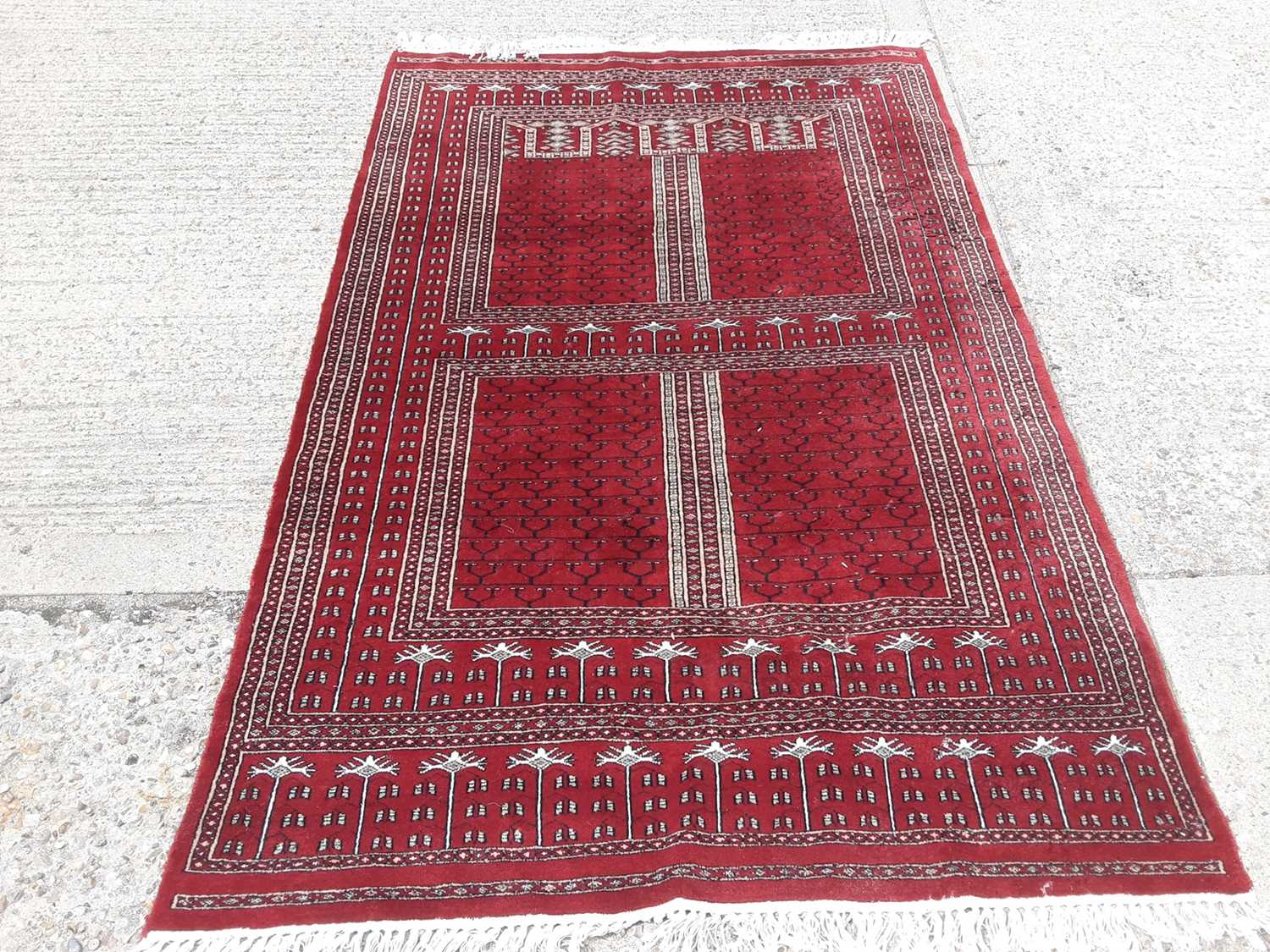 Lot 412 - Eastern rug with geometric decoration on red ground, 211cm x 140cm