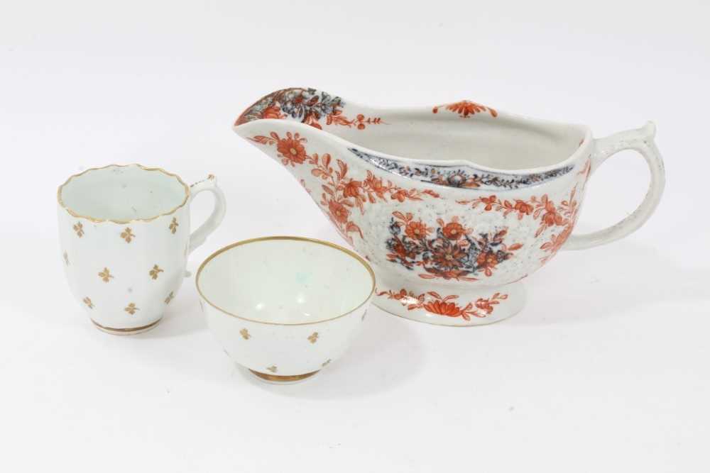 Lot 263 - Lowestoft sauceboat, of large moulded form, painted in blue with flower sprays highlighted in red enamel and gold, 21cm long, together with a Lowestoft coffee cup, of faceted form with scrolled han...