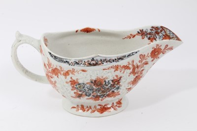 Lot 263 - Lowestoft sauceboat, of large moulded form, painted in blue with flower sprays highlighted in red enamel and gold, 21cm long, together with a Lowestoft coffee cup, of faceted form with scrolled han...