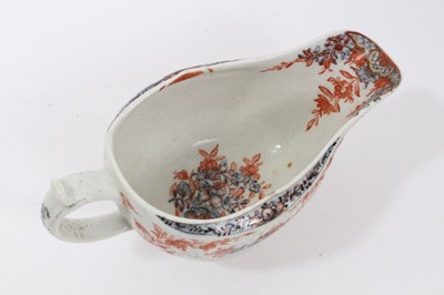Lot 263 - Lowestoft sauceboat, of large moulded form, painted in blue with flower sprays highlighted in red enamel and gold, 21cm long, together with a Lowestoft coffee cup, of faceted form with scrolled han...