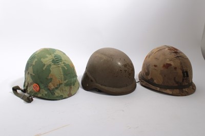 Lot 811 - American M1 Steel helmet with liner, chin and neck strap with cover and anti-war badge, together with an American M1C steel helmet (paratroop version) and an American PASGT helmet (3)