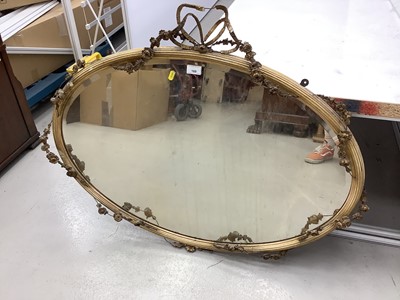 Lot 169 - Oval wall mirror in ornate gilt frame with ribbon and swag decoration, 100cm x 77cm