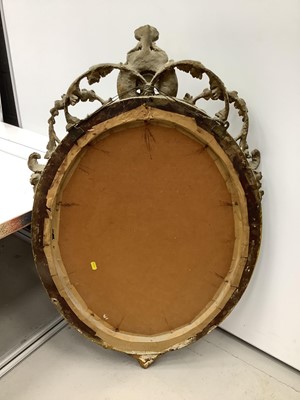 Lot 170 - Oval wall mirror in green and gilt frame with cherub mount, 100cm x 61cm