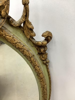 Lot 170 - Oval wall mirror in green and gilt frame with cherub mount, 100cm x 61cm