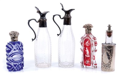 Lot 892 - Pair of Georgian silver mounted cut glass decanters, 17cm high, together with two 19th century silver lidded overlaid glass scent bottles and a silver clad scent. (5)