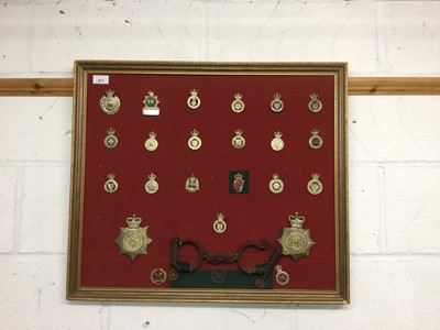 Lot 817 - Collection of various Elizabeth II Police Constabulary badges and helmet plates, mounted on a board with a of antique hand cuffs