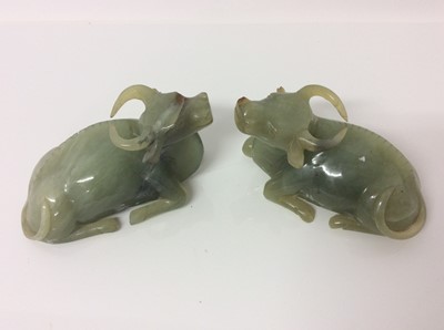Lot 943 - Chinese jade or green hardstone carving, depicting a family of monkeys, utilising the colours in the stone, 3cm high, together with a pair of jade or green hardstone figures of reclining buffalo an...