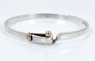 Lot 149 - Tiffany & Co. silver bangle with hook and eye fitting and 18ct gold mounts. London, 1959