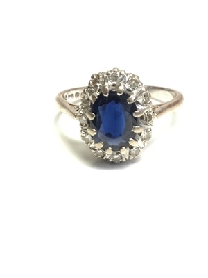 Lot 623 - Sapphire and diamond cluster ring with an oval mixed cut blue sapphire surrounded by a border of single cut diamonds in claw setting on 18ct white gold shank