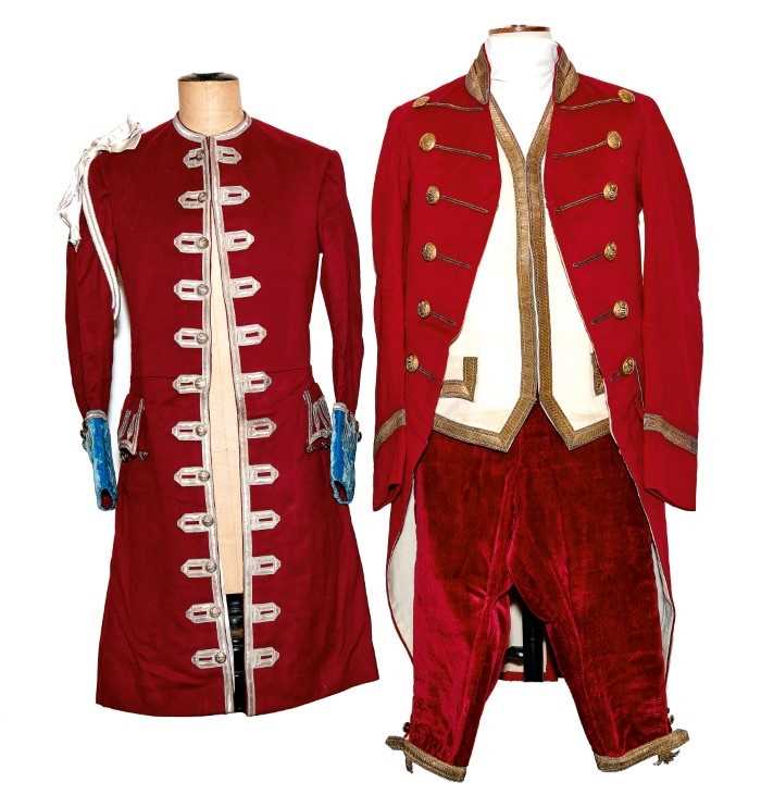 Lot 75 - Fine Edwardian footmans livery for the Earl of Listowel comprising a red frock coat with gold lace and gilt armorial buttons, pair red velvet breeches, cream waistcoat with gold lace and another co...
