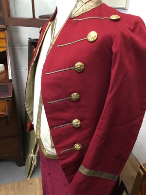 Lot 75 - Fine Edwardian footmans livery for the Earl of Listowel comprising a red frock coat with gold lace and gilt armorial buttons, pair red velvet breeches, cream waistcoat with gold lace and another co...