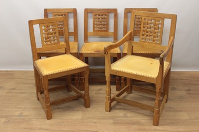 Lot 1297 - Set of five Robert Mouseman Thompson carved oak dining chairs, each with lattice carved back and close stud leather upholstery on chamfered supports with signature mouse to front leg, to include on...