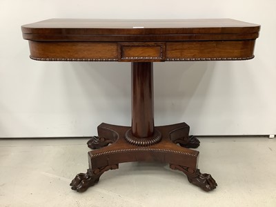 Lot 174 - 19th century rosewood card table with foldover revolving top on turned column and quatrefoil base with carved paw feet, 90.5cm wide x 14.5cm high