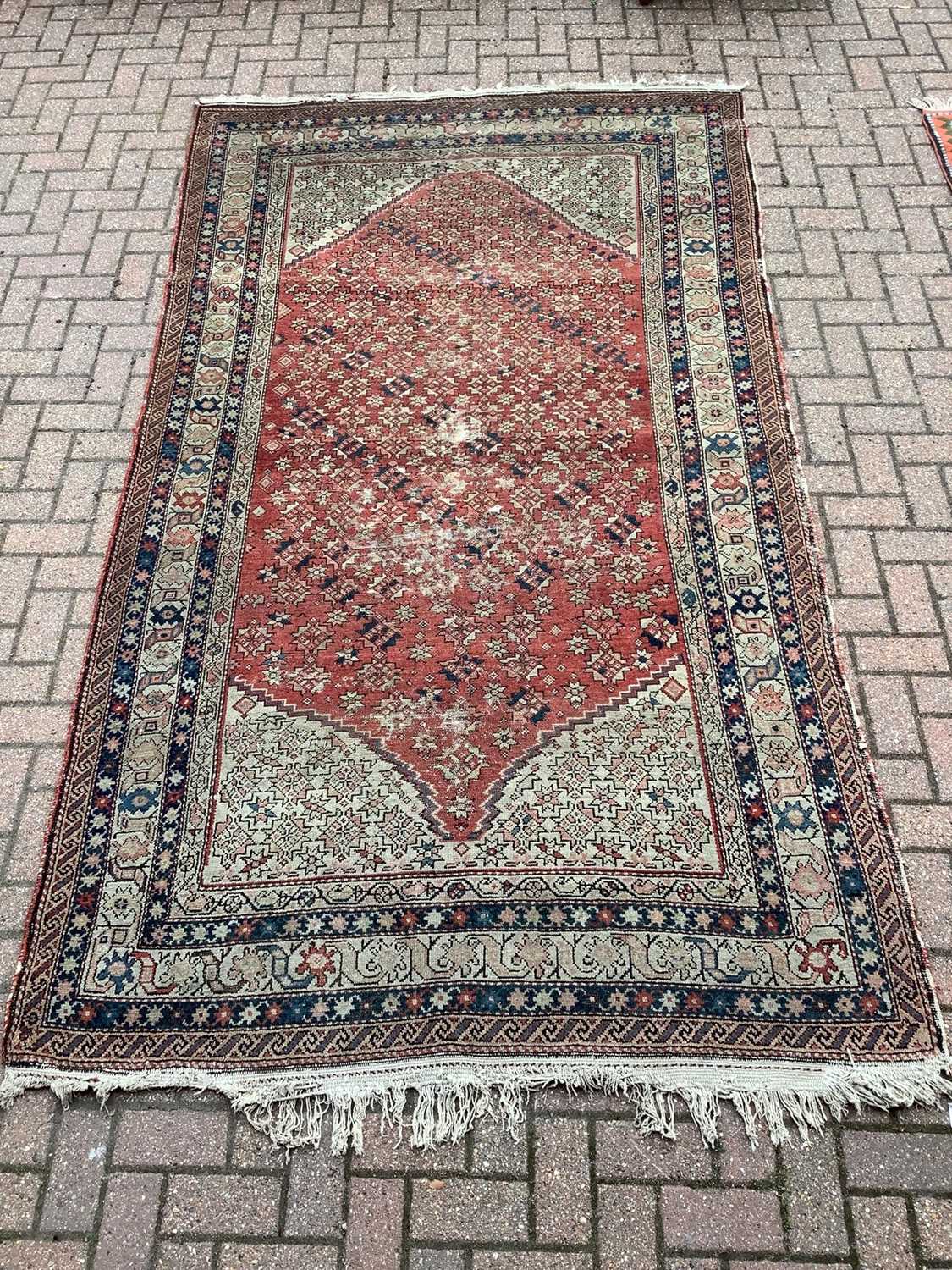 Lot 185 - Eastern rug with geometric decoration on red,blue and beige ground, 305cm x 163cm