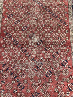 Lot 185 - Eastern rug with geometric decoration on red,blue and beige ground, 305cm x 163cm