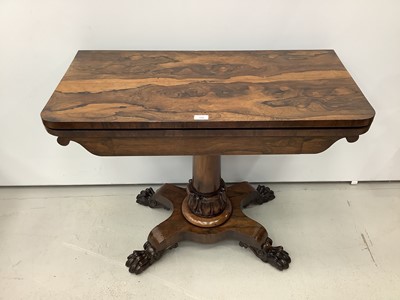 Lot 180 - 19th century rosewood card table with foldover revolving top on turned column and quatrefoil base with carved paw feet, 92cm wide x 74.5cm high