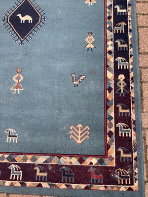 Lot 187 - Old rug decorated with figures and animals on blue ground  228cm x 160cm
