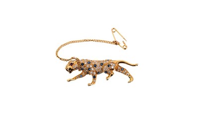 Lot 666 - Cartier style diamond and sapphire 18ct gold leopard brooch with pavé set brilliant cut diamonds and mixed cut sapphires, ruby eyes in 18ct yellow gold setting. 40mm length.