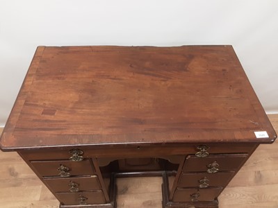 Lot 942 - George II mahogany kneehole desk, the crossbanded top with re-entrant corners