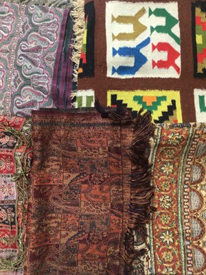 Lot 1963 - A lot of woven textiles including Indian Cashmire shawls, other woven Paisley shawls, colourful woven wall hanging, Iranian printed cotton shawl and other items.