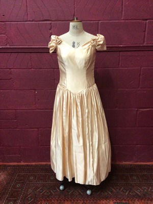 Lot 2155 - Three vintage wedding dresses, including 1950s satin and lace, 1980s Oyster satin, pointed waistline and rosetts on dropped shoulders by Berkertex, a cream satin dress with heavily beaded bodice...