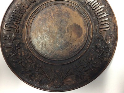 Lot 342 - French treen bread board, carved in relief with a motto and foliate patterns, 28cm diameter