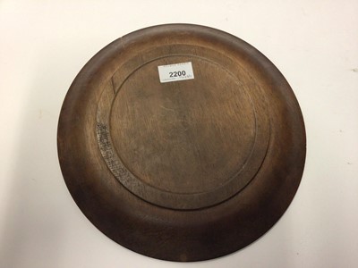 Lot 342 - French treen bread board, carved in relief with a motto and foliate patterns, 28cm diameter