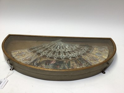 Lot 2296 - 19th century mother of pearl and paper fan, the sticks carved and the paper printed, hand-coloured and gilt with figural scenes and classical motifs, in a glass display case