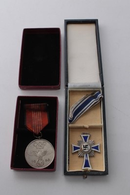 Lot 763 - Nazi German Mothers Cross (silver award) in box of issue, together with a 1936 Berlin Olympics medal in box of issue (2)