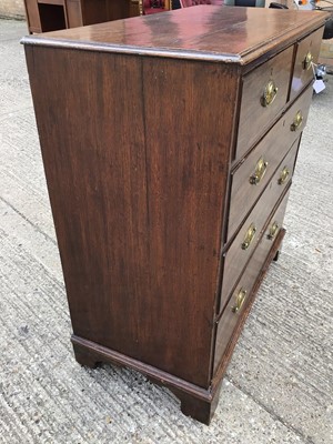 Lot 911 - George III oak chest of two short and three long drawers with oval brass handles, on bracket feet