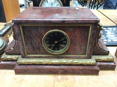 Lot 2364 - Red marble mantel clock with brass mask and ring handles and ornamentation, bell strike, French movement, 55cm wide