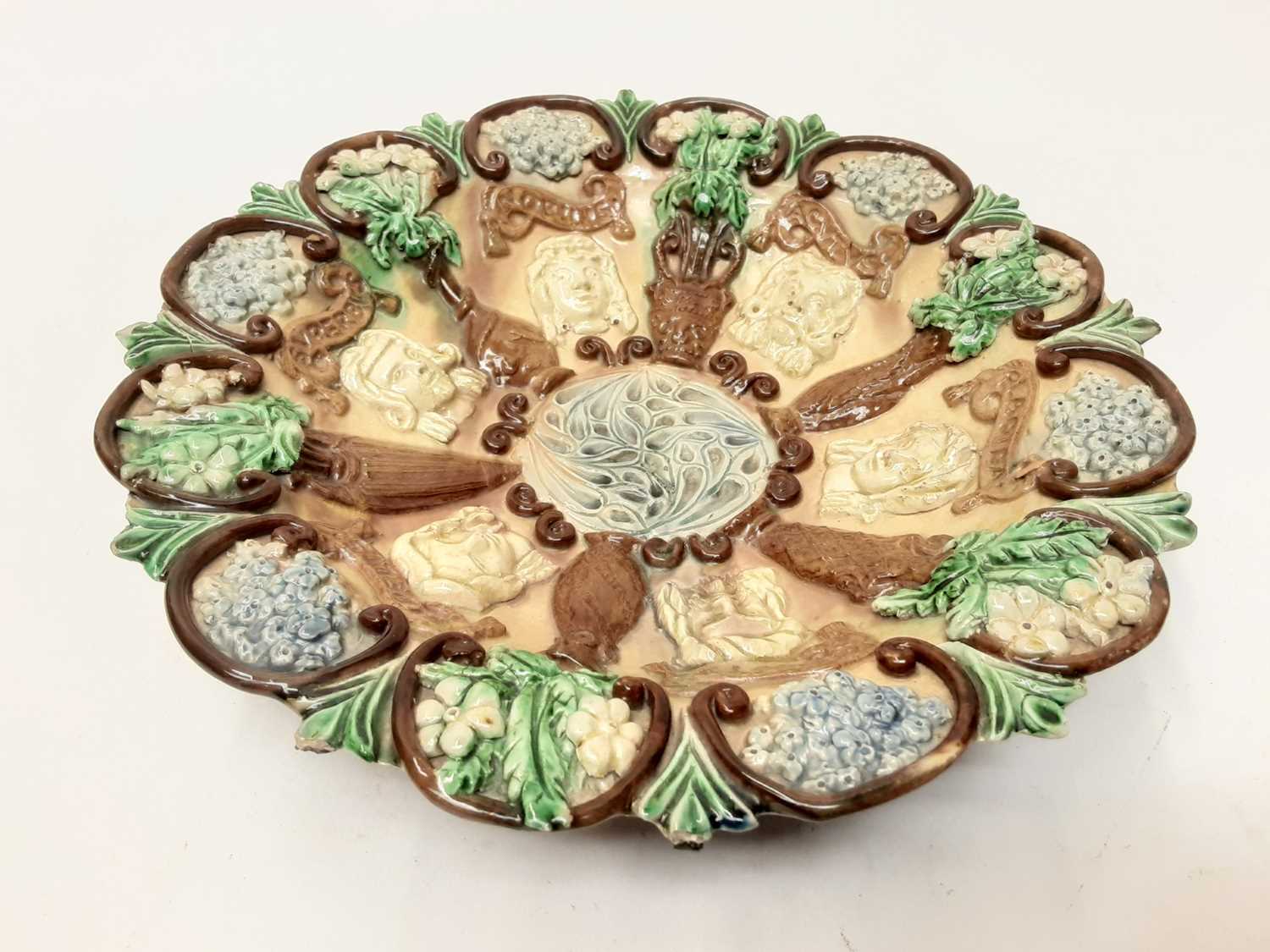 Lot 91 - Castle Hedingham Edward Bingham pottery dish decorated with masks and flowers on brown and green ground, 25cm diameter