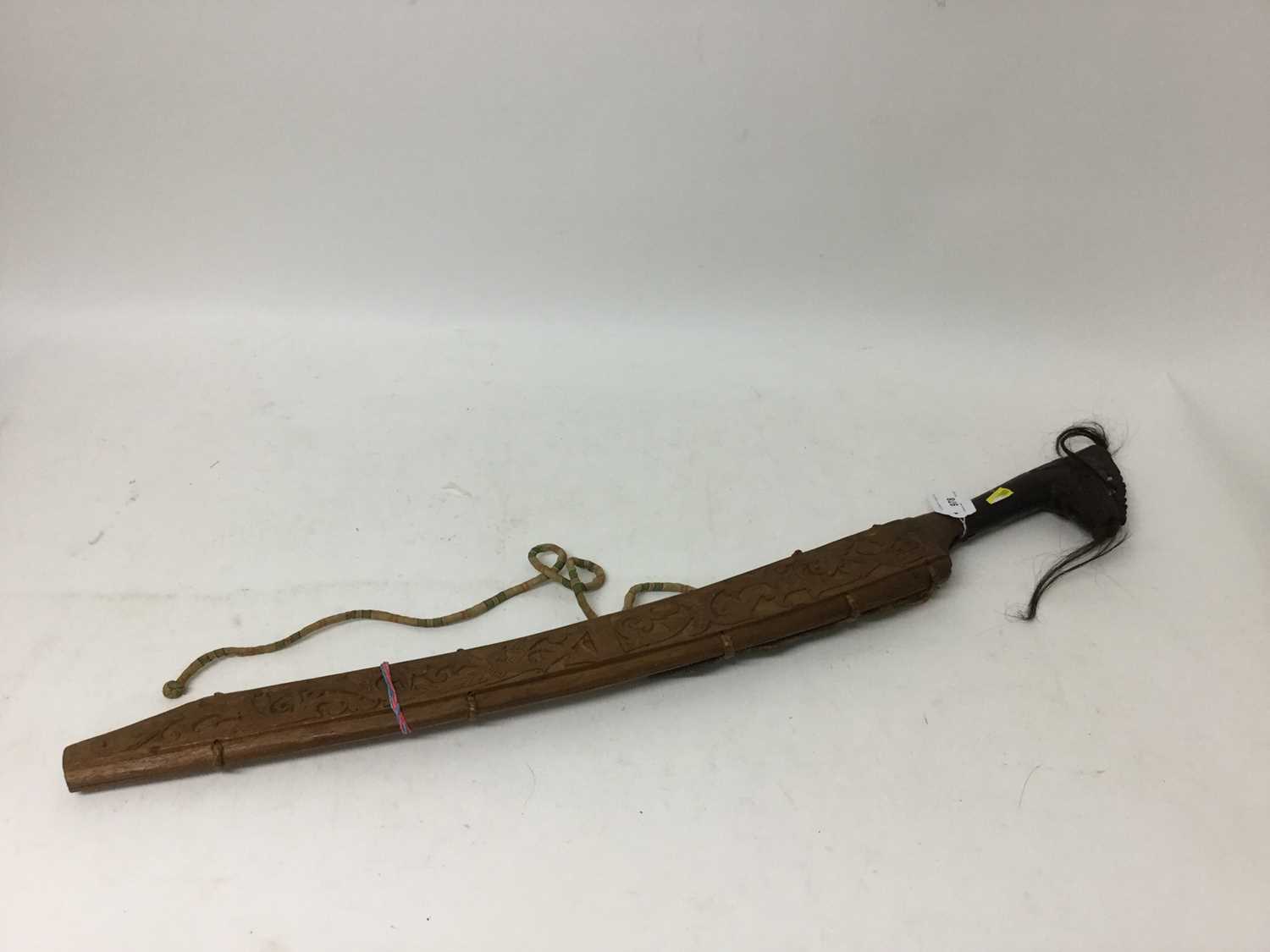 Lot 978 - Borneo Dayak Head hunters sword with steel blade, carved ebonised wood hilt, in ornately carved wood scabbard