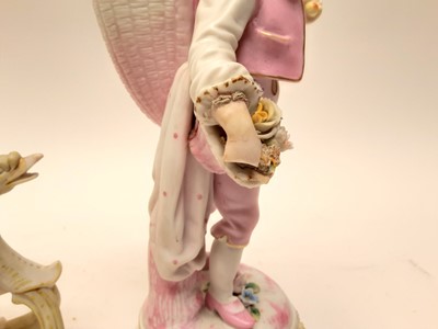 Lot 88 - Bisque porcelain figure of a boy carrying a basket on his back, and a bisque porcelain cherub riding a sledge (2)