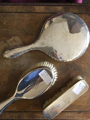 Lot 2415 - Sterling silver dressing table set, including two brushes and a mirror (the mirror not matching the other two)