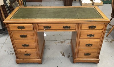 Lot 854 - Late 19th / early 20th century satin birch desk, with green leather top and nine drawers about the kneehole on plinth base and castors, 138cm wide x 67cm x 82cm high