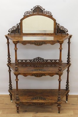 Lot 1434 - Victorian inlaid burr walnut veneered three tier whatnot with arched mirrored back, three marquetry inlaid shelves on carved and turned supports terminating on original ceramic castors