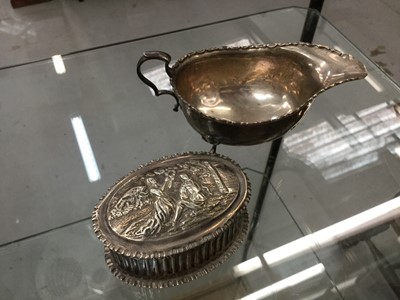 Lot 663 - Victorian silver box of oval form with embossed Dutch style decoration (London 1880), together with a silver sauce boat, 199 grams