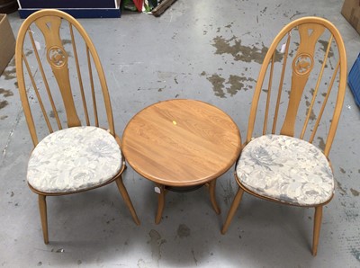 Lot 857 - Ercol two tier coffee table with circular top and glass undertier model number 1061, H47, W60cm together with a pair of Ercol swan back chairs