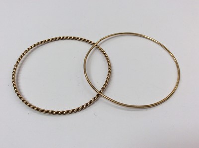 Lot 671 - Two 9ct gold bangles to include one plain and one rope twist