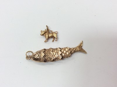 Lot 675 - 9ct gold articulated fish pendant and 9ct gold cow charm (2)