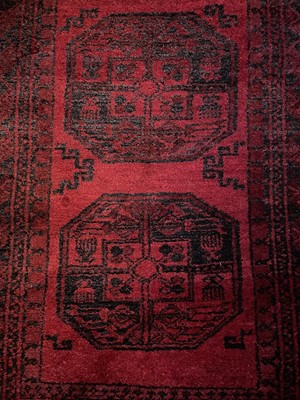Lot 898 - An antique Eastern rug with geometric medallions on blue and red ground, 130cm x 82cm, together with another on red ground, 118cm x 88cm (2)