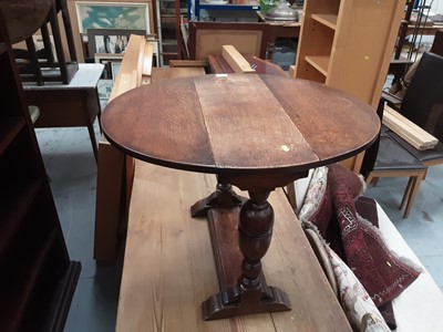 Lot 873 - Oak drop leaf table on turned end standards and a nest of three oak occasional tables