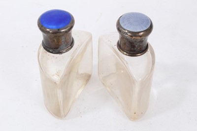 Lot 263 - Two early 20th century glass scent bottles with silver and guilloche enamel tops in  a leather case
