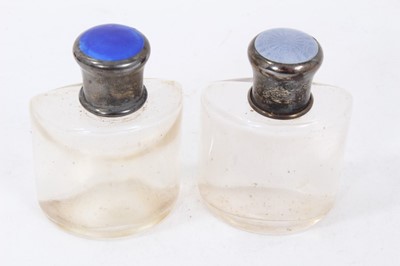 Lot 263 - Two early 20th century glass scent bottles with silver and guilloche enamel tops in  a leather case