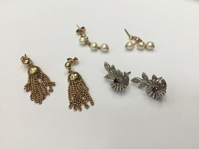 Lot 684 - Three pairs of gold earrings to include a pair of 9ct white gold diamond and ruby flower earrings, 9ct gold tassel earrings and a pair of cultured pearl drop earrings