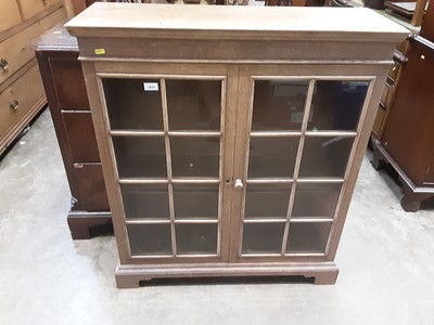 Lot 1031 - Blond oak dwarf bookcase, enclosed by two astragal glazed doors, 88cm wide x 103cm high x 27cm deep