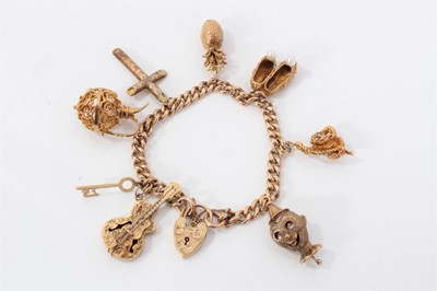 Lot 580 - 9ct gold charm bracelet with eight 9ct gold charms and padlock clasp