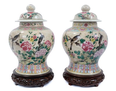Lot 1 - Pair of Chinese famille rose porcelain crackle-glazed jars and covers with carved hardwood stands, approximately 26cm excluding stands.