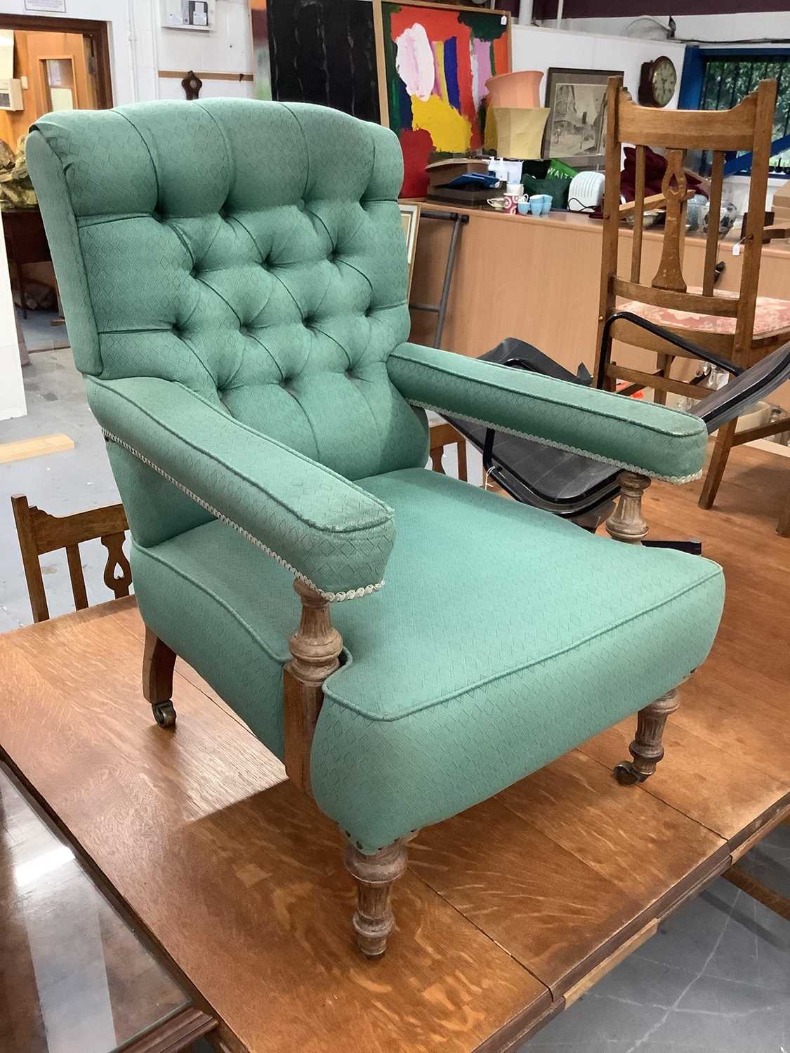 Lot 851 - Victorian armchair upholstered in buttoned green material with turned beech legs on brass castors